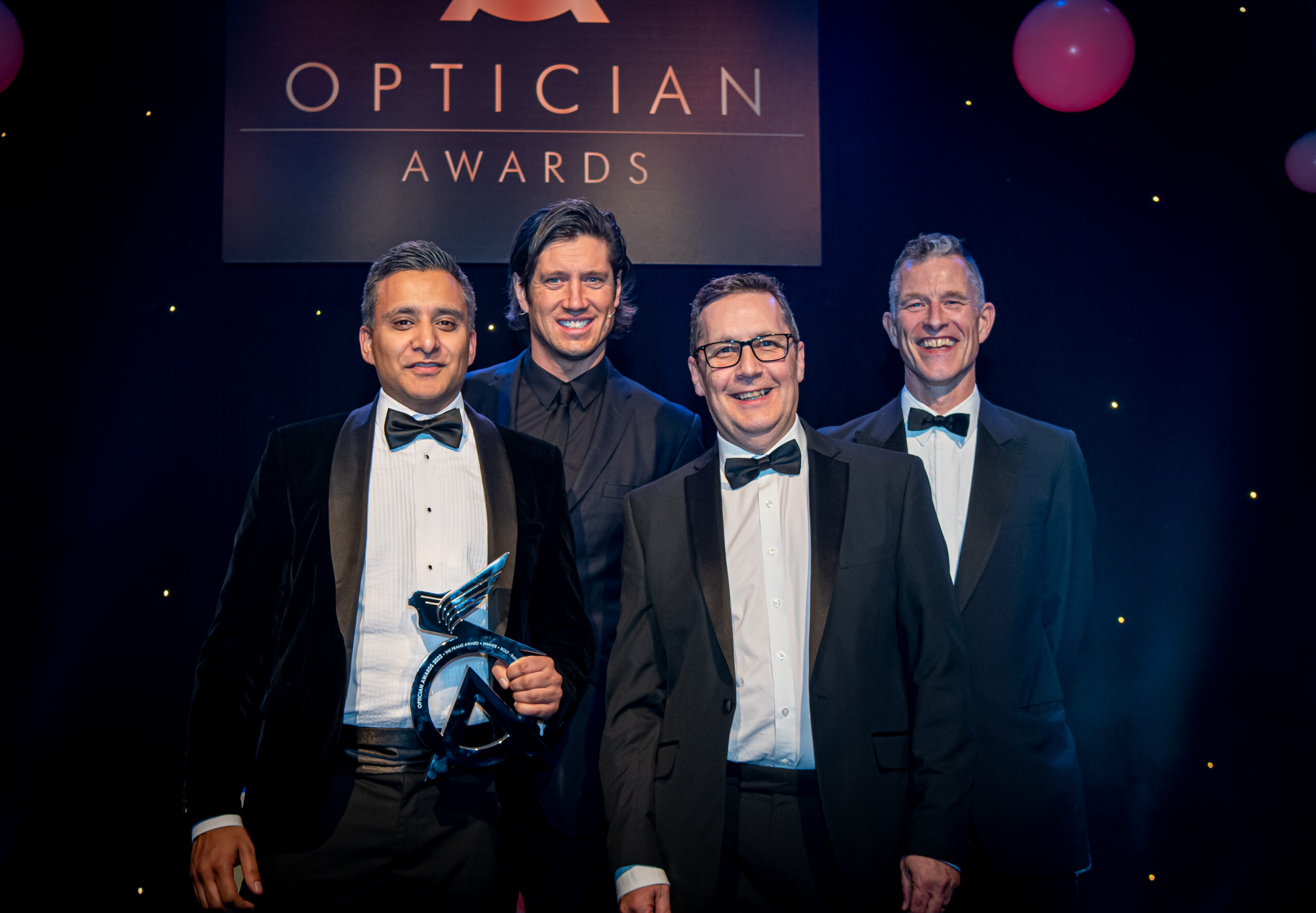Harvey Dhadwar (image left) CEO at UK Eyewear and Distributor for rolf in the UK on stage receiving the optician awards throphy